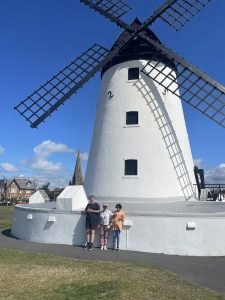 Large white windmill with people standing in front of it.