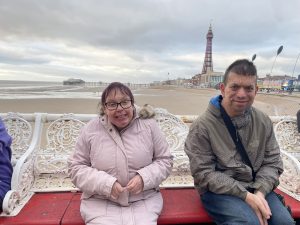 People sat on bench in front of Blackpool tower