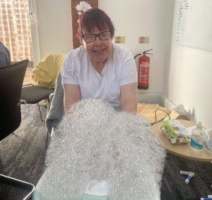 Woman in white tshirt and glasses with hands in bubbles